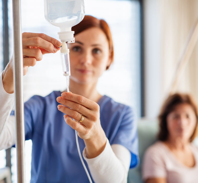 Nurse preparing NAD+ IV infusion for patient therapy session in a wellness clinic.